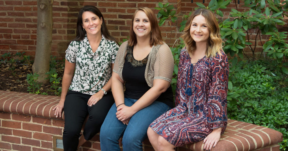 Employees sitting on brick wall