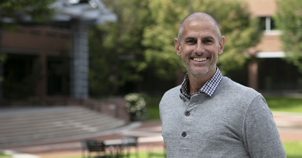 Man smiling with grey sweater