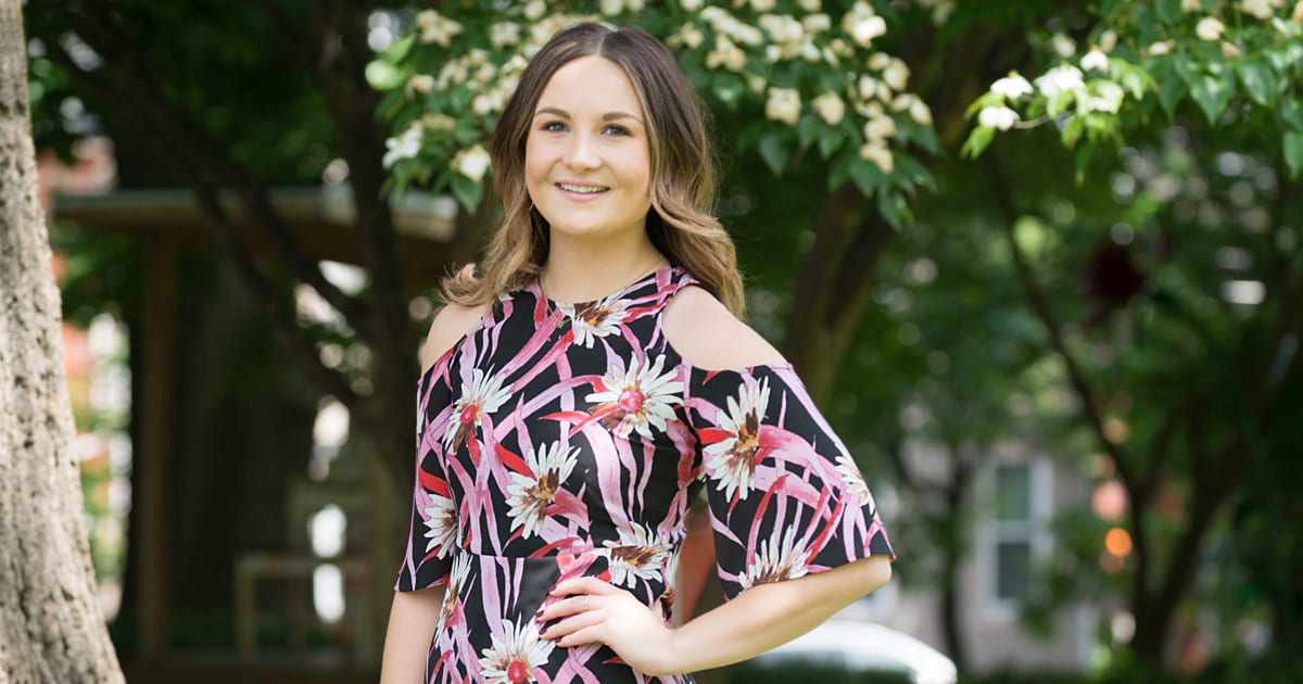 woman in floral print dress standing outside