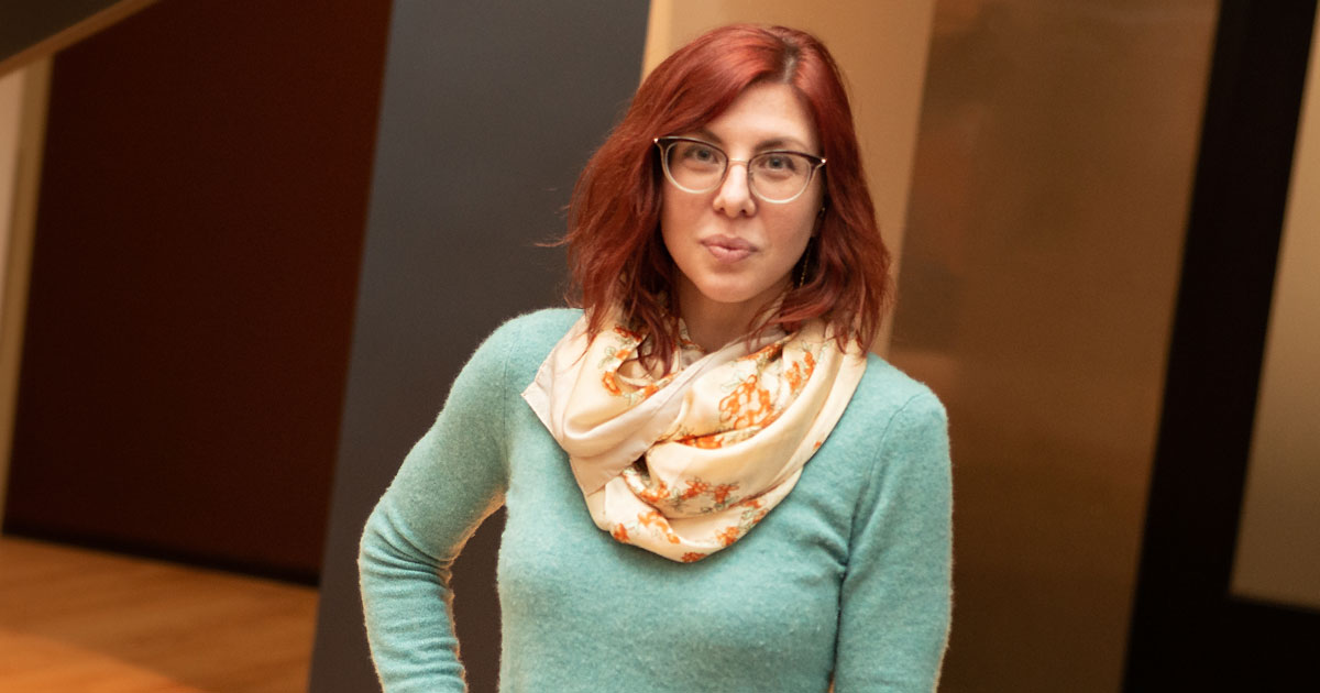Woman with red hair wearing green sweater