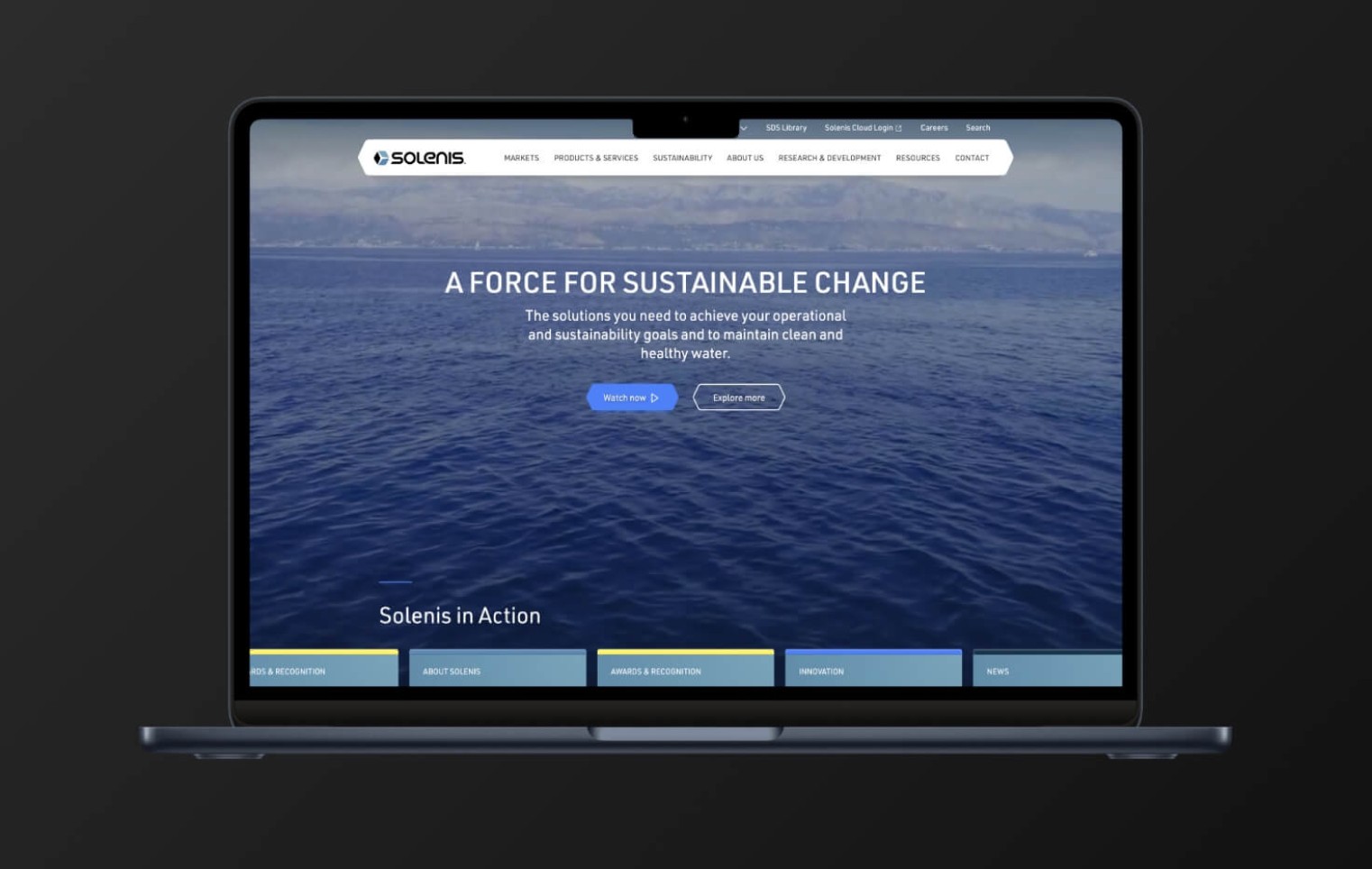 Laptop displays a corporate website homepage with ocean imagery, showcasing a modern, responsive business website design.