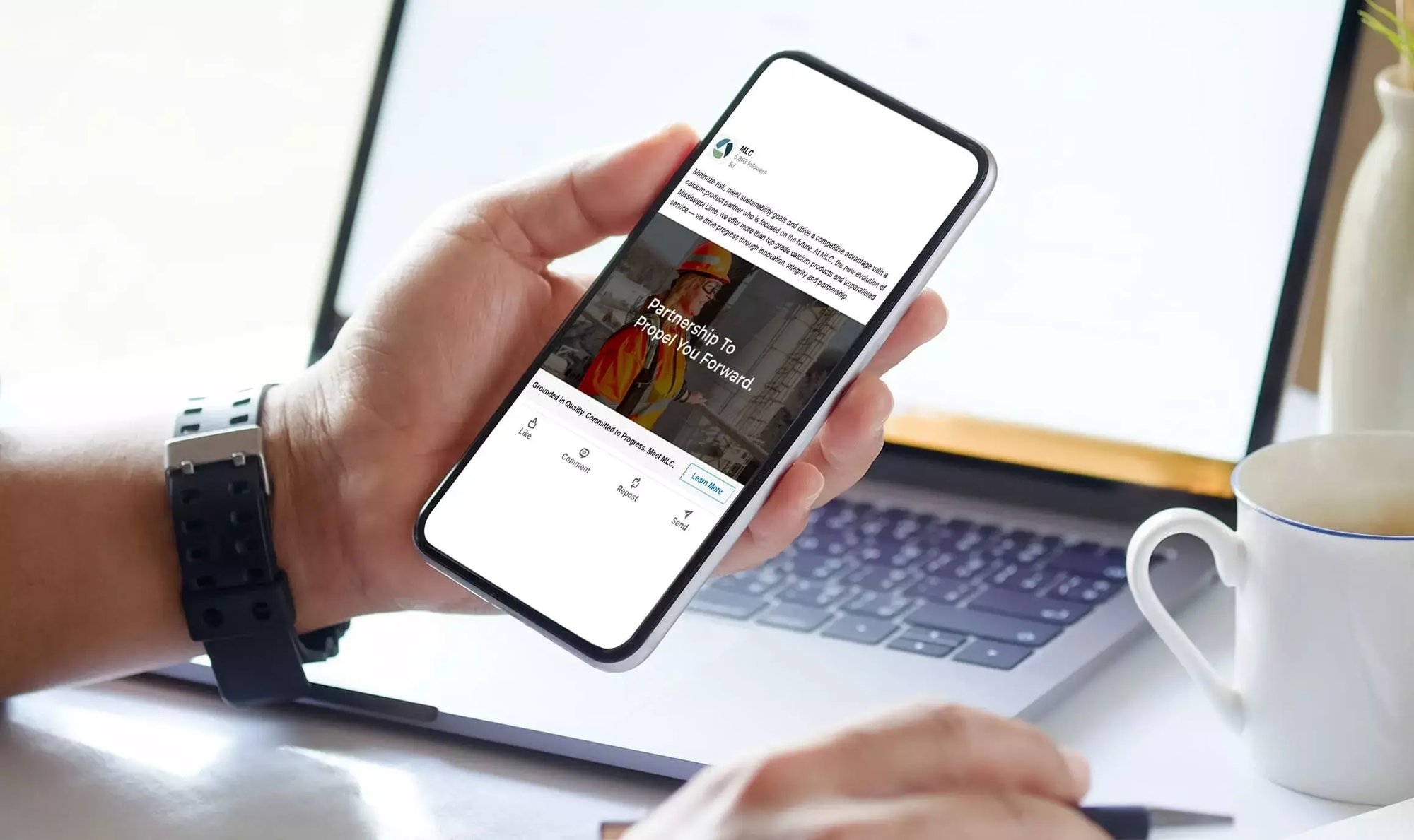 Person holds a smartphone displaying an MLC LinkedIn ad featuring an industrial worker and new brand messaging.