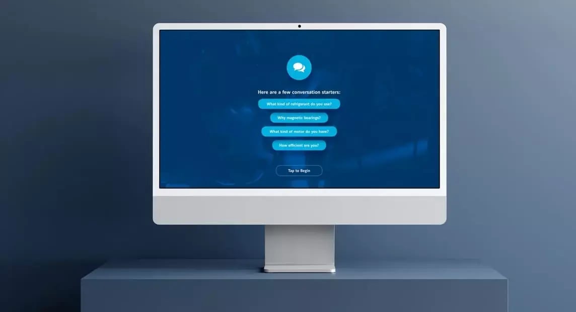 Desktop monitor displays the YORK YZ chiller chatbot with questions about refrigerant, bearings and efficiency.