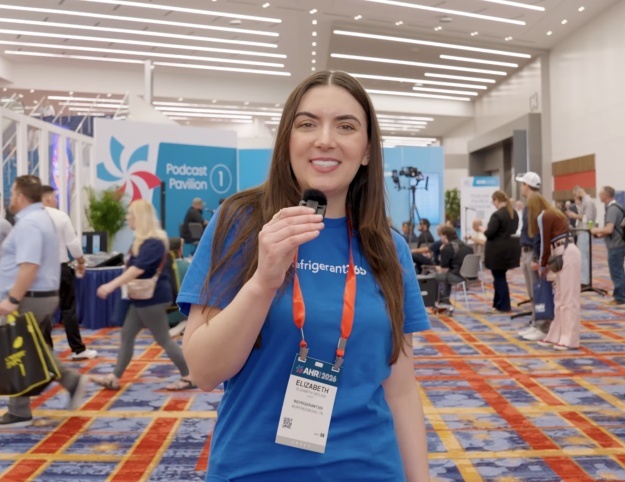 Refrigerant365 representative speaks into a microphone on the busy show floor at the 2026 AHR Expo.