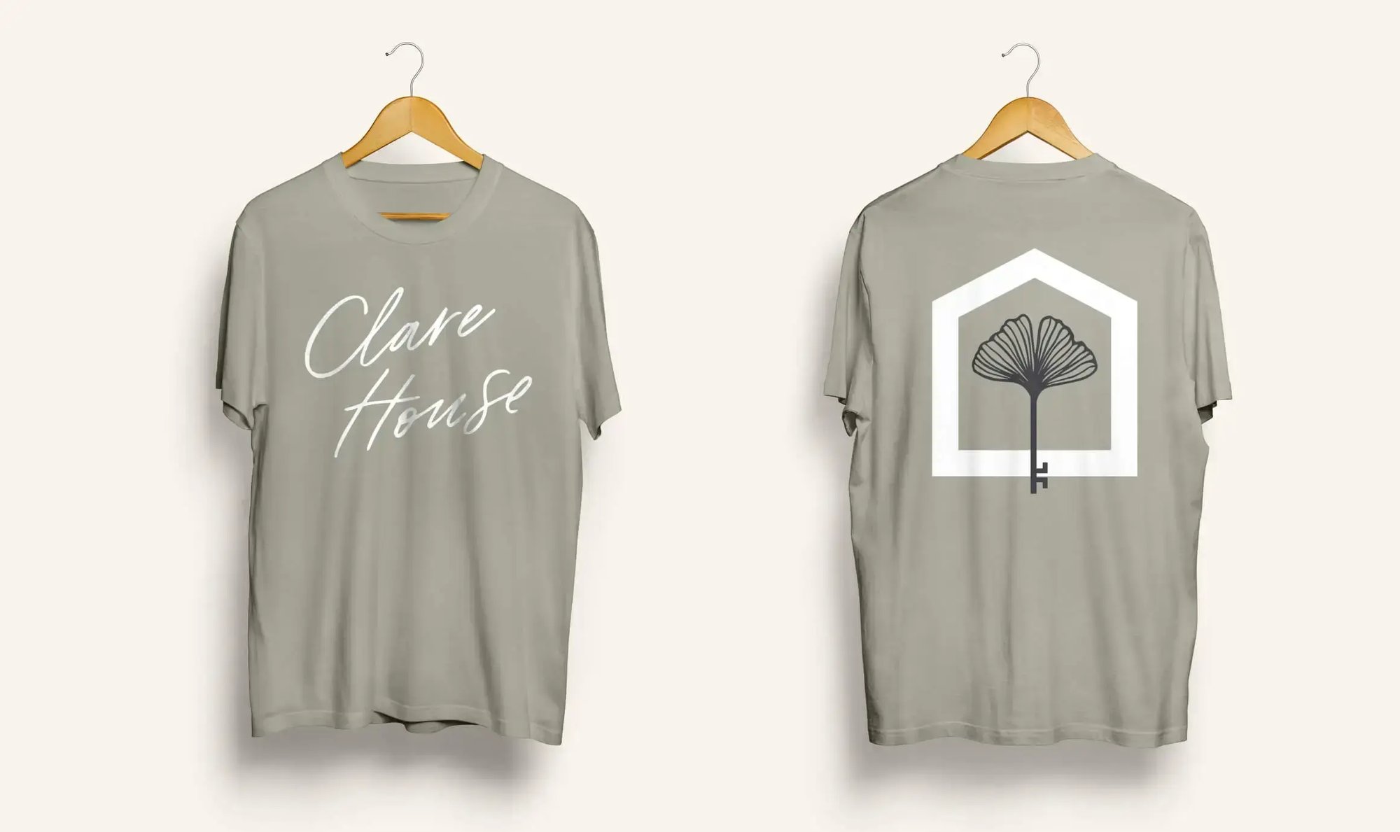 Front and back views of Clare House branded T-shirts featuring the organization’s wordmark and house-and-flower logo identity.