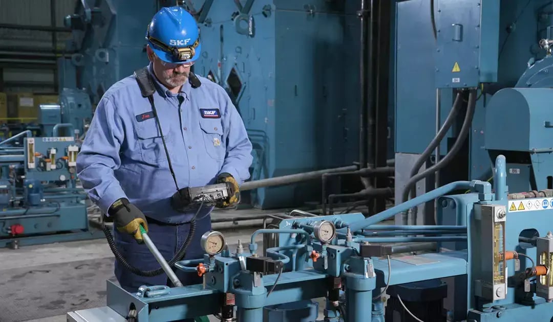 SKF technician uses monitoring equipment to inspect large industrial machinery at the Big River Steel facility.