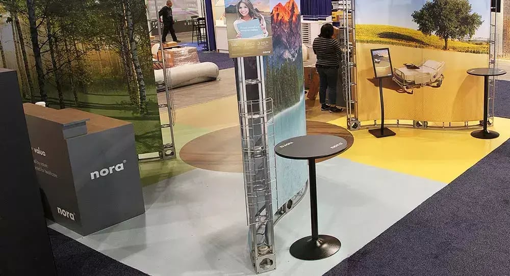 noraplan valua trade show booth combines colorful flooring, nature graphics and healthcare imagery to create an immersive experience.