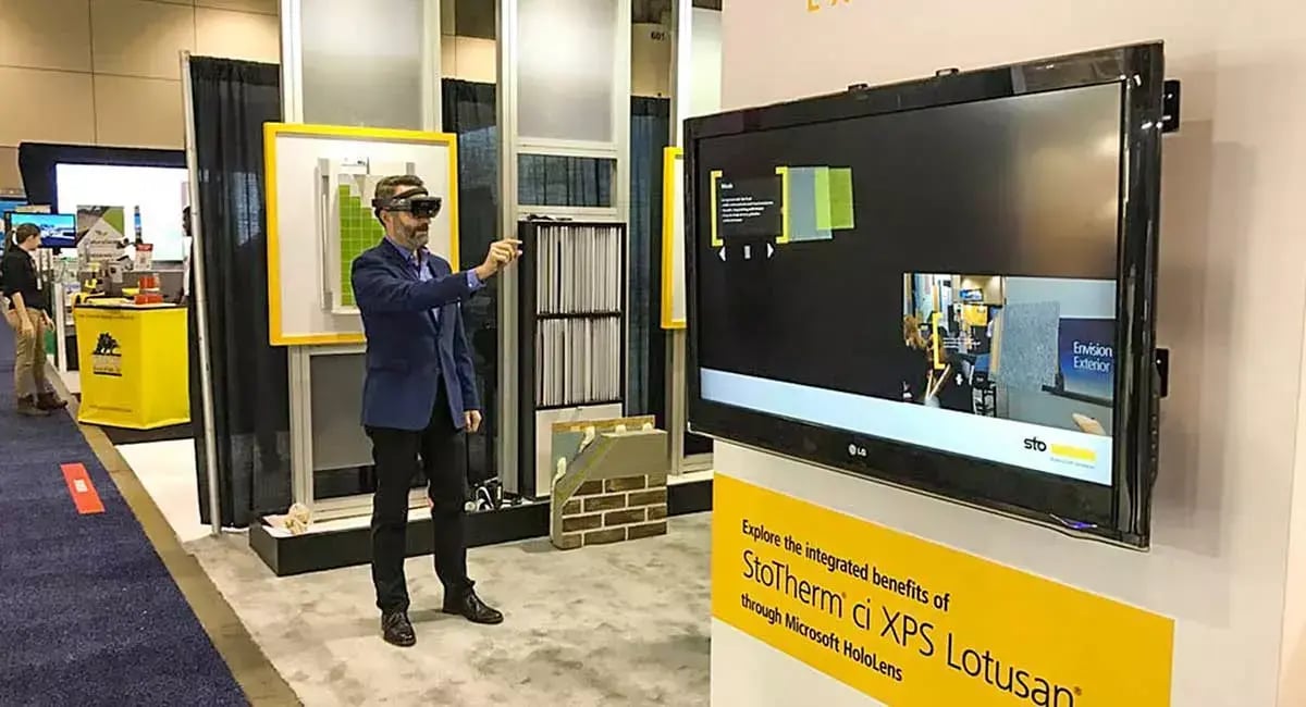 Trade show attendee uses Microsoft HoloLens to explore the StoTherm ci XPS Lotusan exterior wall system through an interactive display.