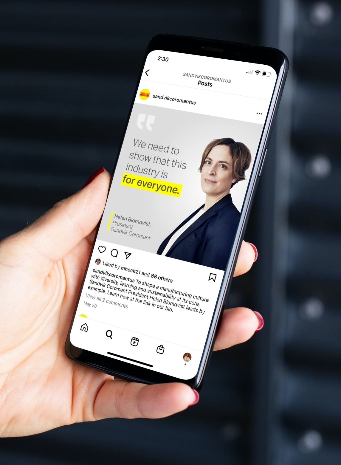 Hand holds a phone displaying a Sandvik Coromant post featuring Helen Blomqvist and the message, “This industry is for everyone.”