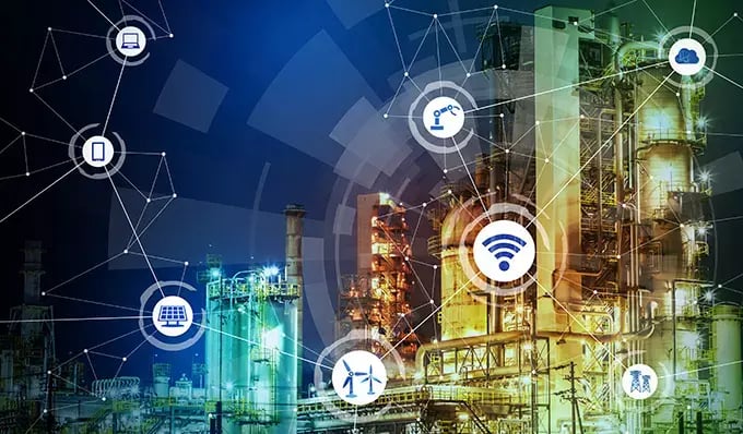 Industrial facility overlaid with connected icons for Wi-Fi, cloud, robotics, solar, wind, and devices, illustrating smart manufacturing.